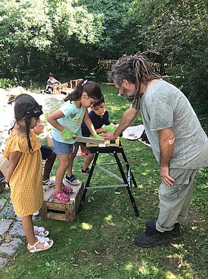 Lehrer zeigt Kindern Holz sägen